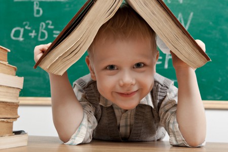 Cheerful smiling  little boy sitting at the table.